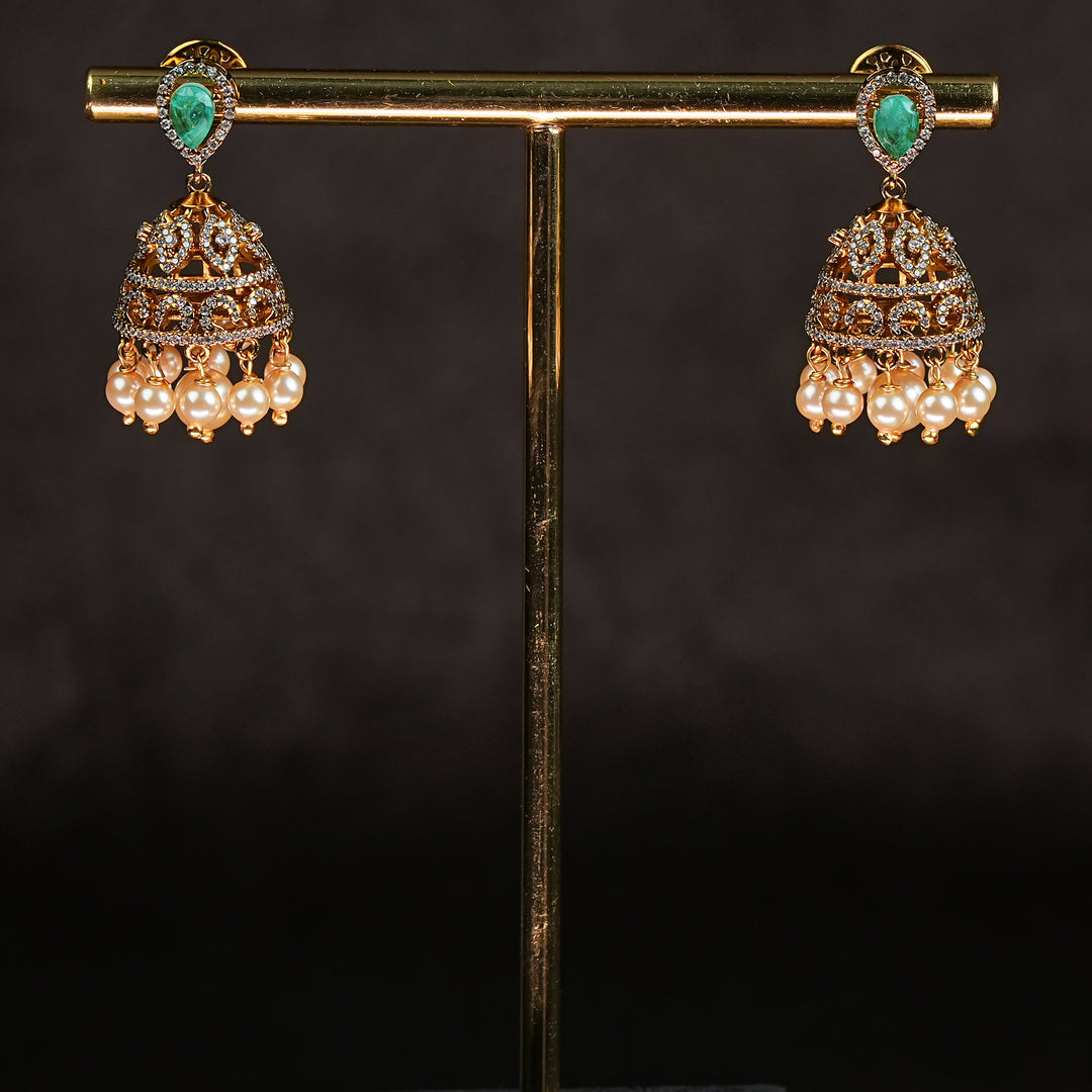 Samairaa emerald green victorian jhumka earrings in 92.5 sterling silver with antique gold finish, pearl hangings and royal bridal design by Sri Fine Jewellery, Hyderabad.
