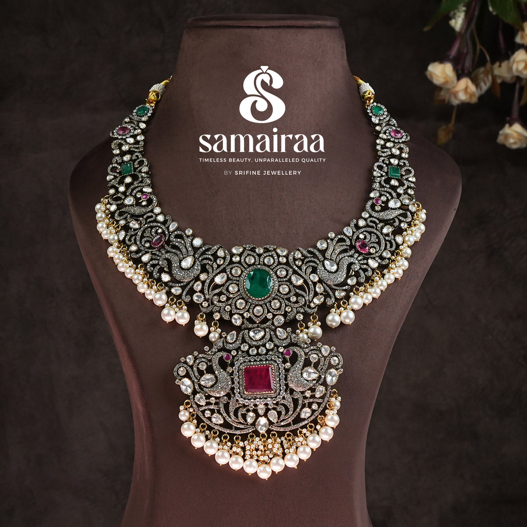 Traditional Samairaa victorian bridal necklace in 92.5 silver with emerald and ruby stones, pearl drops, antique finish and royal heritage jewellery design by Sri Fine Jewellery, Hyderabad. 
