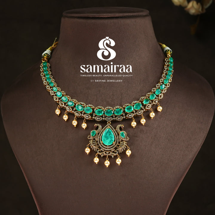 Samairaa emerald green victorian necklace set in 92.5 silver with antique gold finish, pearl hangings and royal bridal design by Sri Fine Jewellery, Hyderabad.
