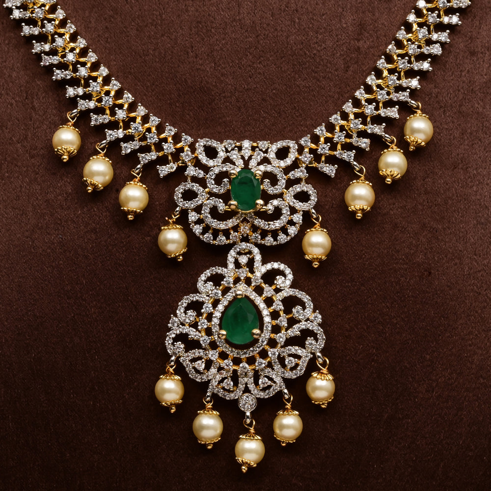 Close-up view of luxury diamond-look silver cz emerald necklace with premium cz stones, semi-precious emerald stone and  pearl drops in 92.5 silver, bridal wedding jewellery with gold finish by Sri Fine Jewellery Punjagutta Hyderabad.