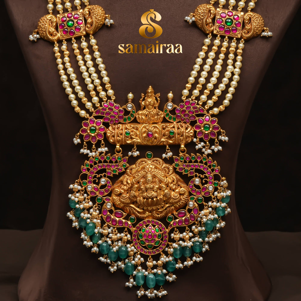 Traditional pearl haram necklace in 92.5 silver with antique gold finish, Lakshmi pendant, kundan stones and green bead drops for South Indian bridal jewellery by Sri Fine Jewellery Hyderabad.