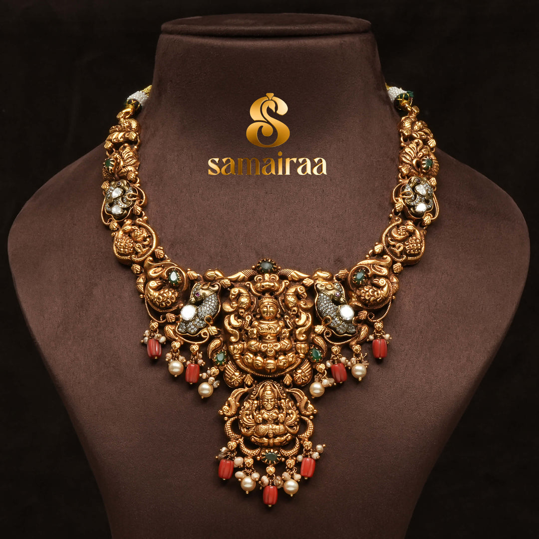 Traditional temple 92.5 silver necklace with antique gold polish, Lakshmi goddess pendant, ruby and emerald stones, pearl drops and South Indian bridal jewellery design by Sri Fine Jewellery Hyderabad.