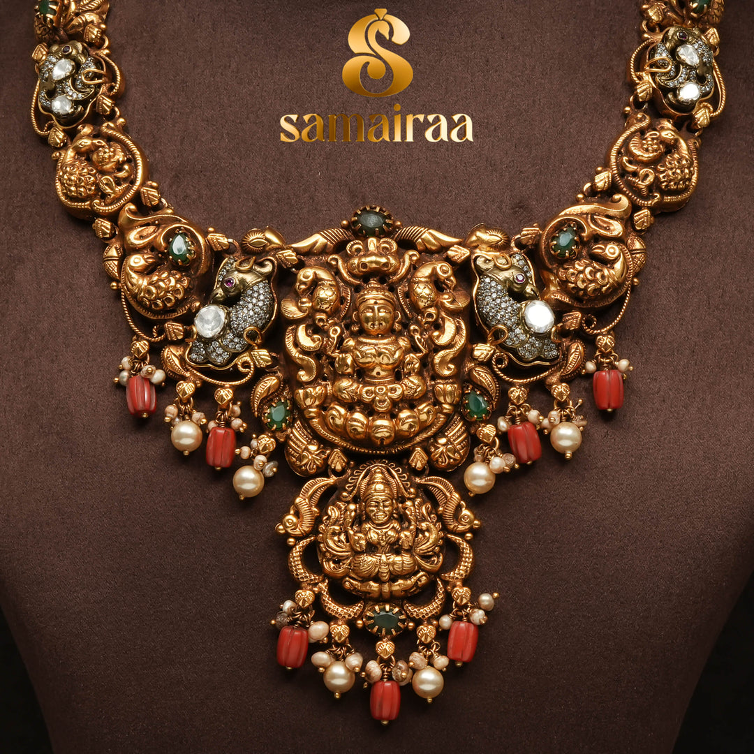 Traditional temple 92.5 silver necklace with antique gold polish, Lakshmi goddess pendant, ruby and emerald stones, pearl drops and South Indian bridal jewellery design by Sri Fine Jewellery Hyderabad.