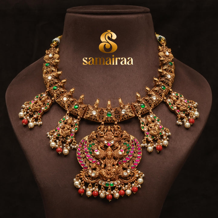 Traditional temple silver necklace with antique gold polish, Lakshmi goddess pendant, ruby and emerald stones, pearl drops and South Indian bridal jewellery design by Sri Fine Jewellery Hyderabad.
