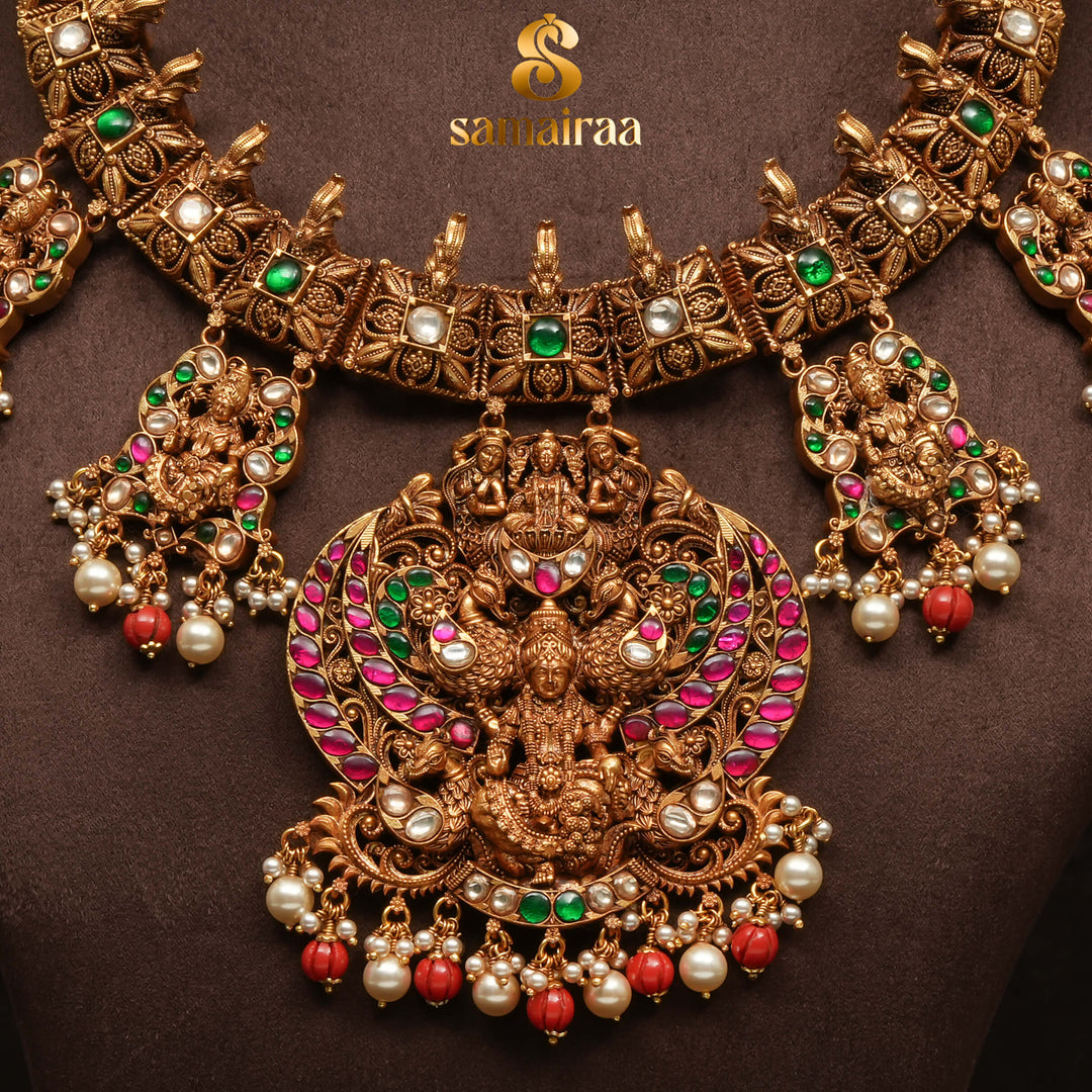 Traditional temple silver necklace with antique gold polish, Lakshmi goddess pendant, ruby and emerald stones, pearl drops and South Indian bridal jewellery design by Sri Fine Jewellery Hyderabad.