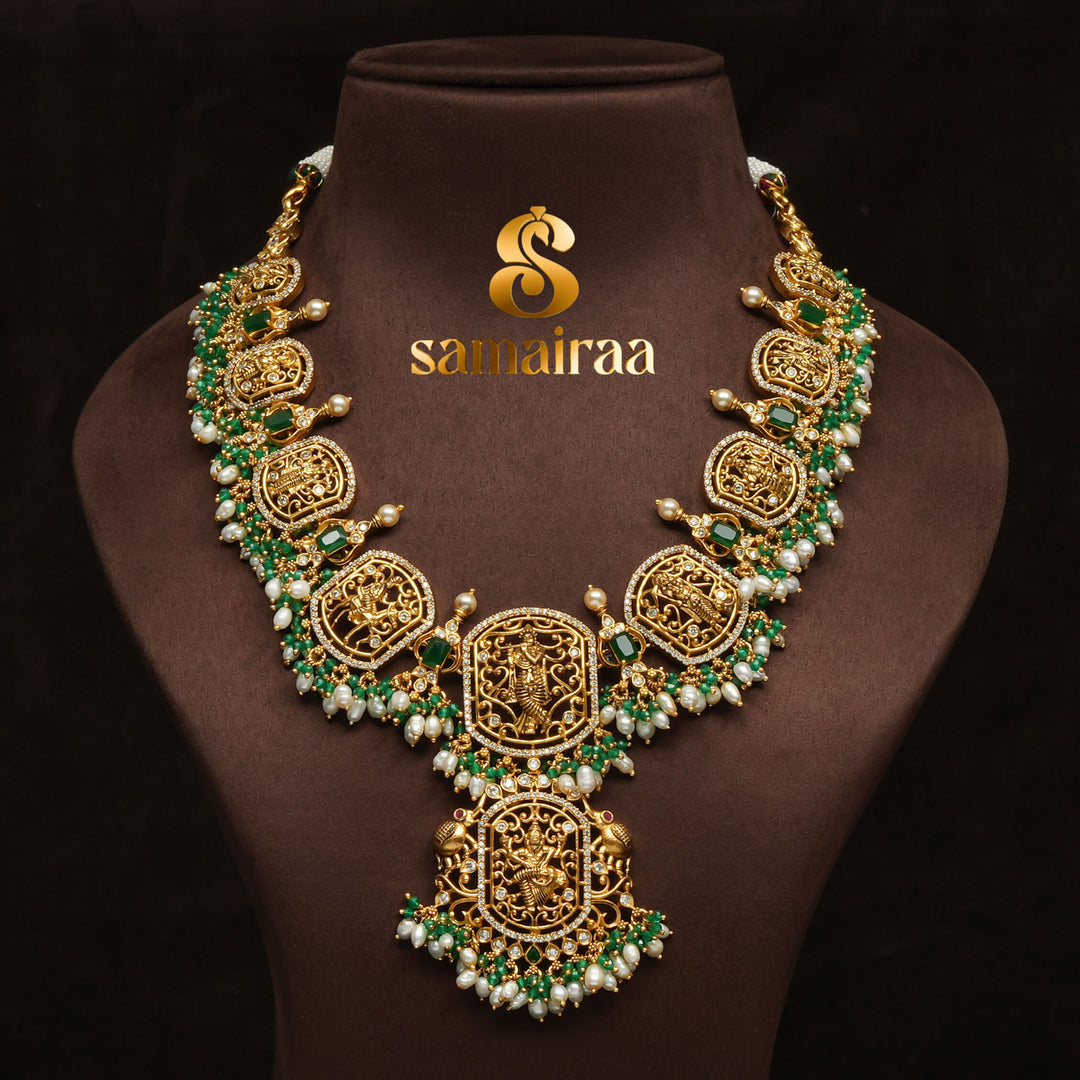 Traditional temple 92.5 silver necklace with antique gold finish, pearl drops, emerald stones and intricate Krishna pendant design by Sri Fine Jewellery, Hyderabad.
