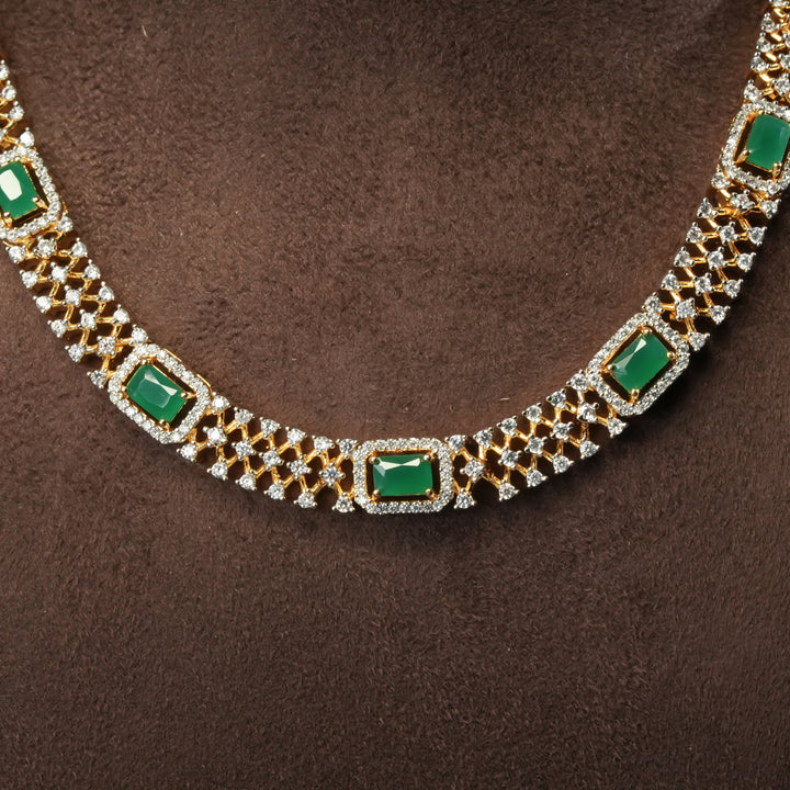 Close-up view of luxury diamond-look silver cz emerald necklace set with premium cz stones and semi-precious emerald stone in 92.5 silver, party wear jewellery with gold finish by Sri Fine Jewellery Punjagutta Hyderabad.