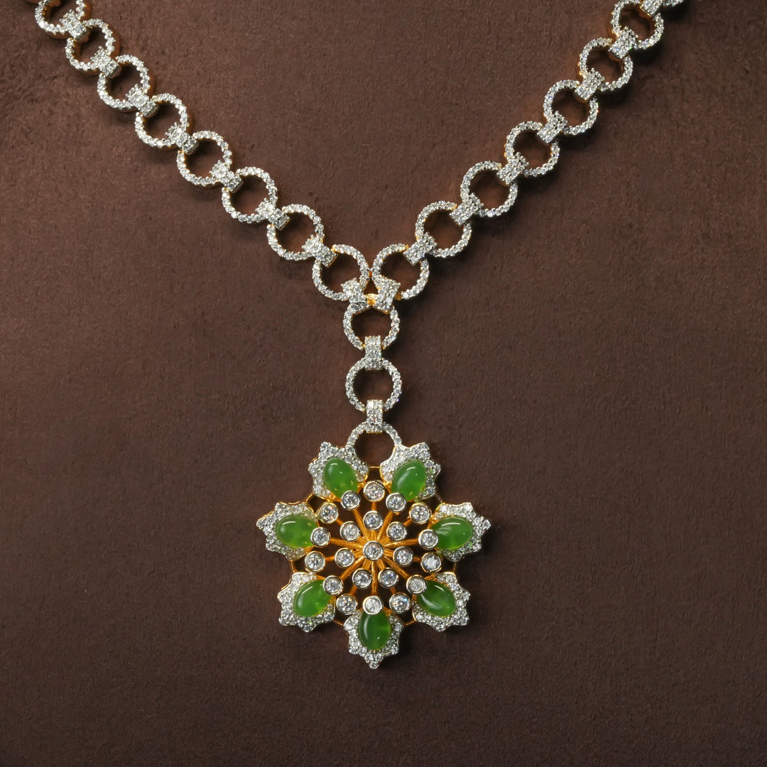 Close-up of luxury diamond-look silver cz emerald necklace with premium cz stones and semi-precious emerald stone in 92.5 silver, party wear jewellery with gold finish by Sri Fine Jewellery Punjagutta Hyderabad.