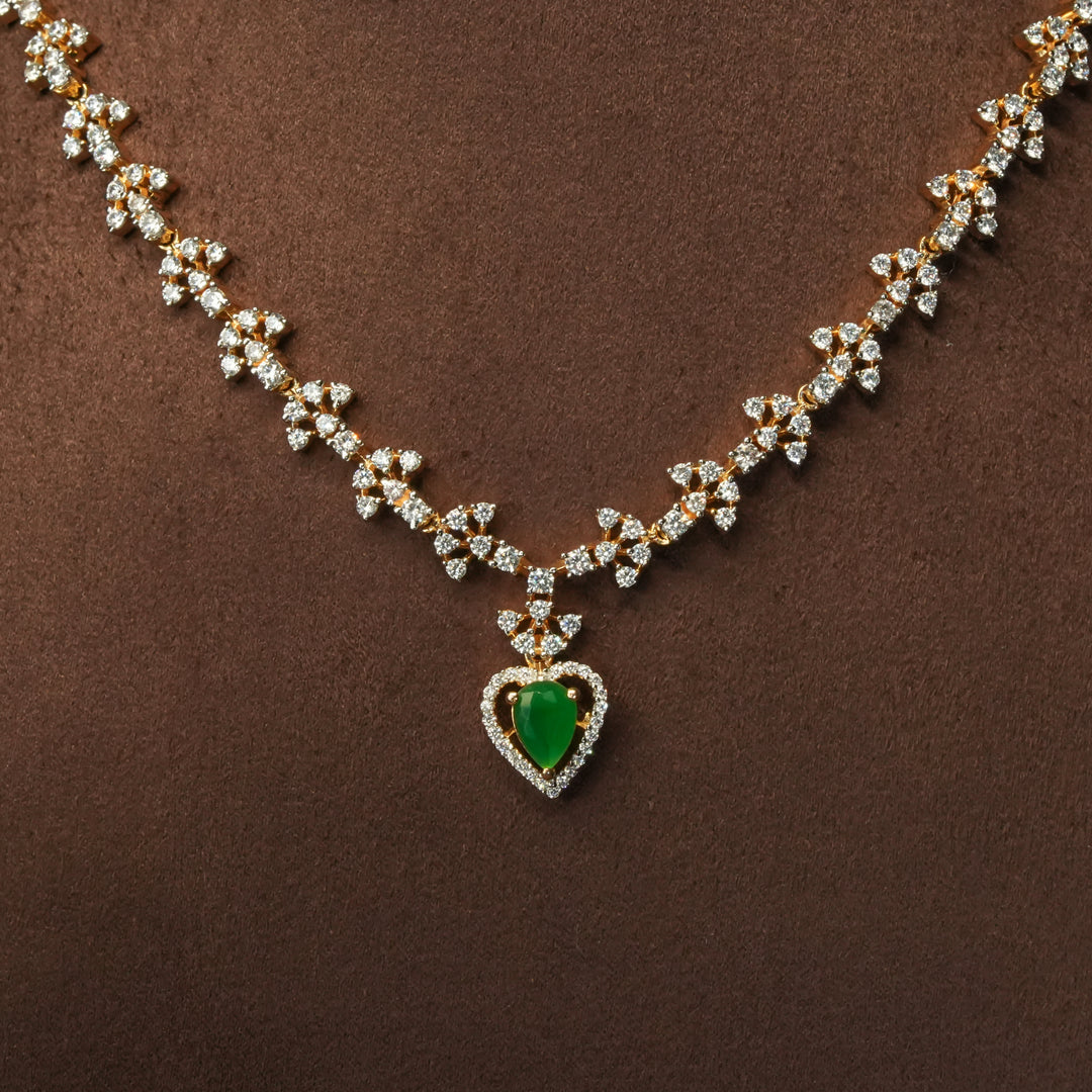 Close-up view of luxury diamond-look silver cz emerald necklace with premium cz stones and semi-precious emerald stone in 92.5 silver, bridal wedding jewellery with gold finish by Sri Fine Jewellery Punjagutta Hyderabad.