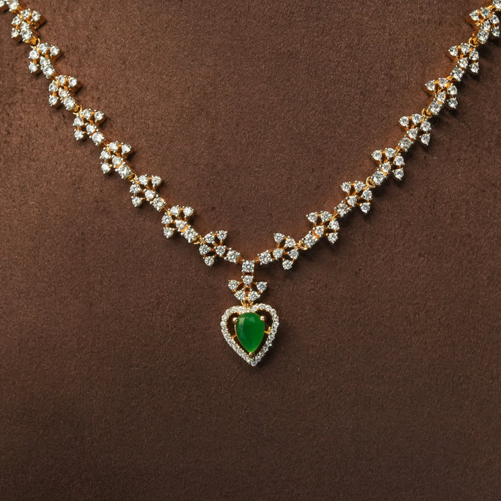 Close-up view of luxury diamond-look silver cz emerald necklace with premium cz stones and semi-precious emerald stone in 92.5 silver, bridal wedding jewellery with gold finish by Sri Fine Jewellery Punjagutta Hyderabad.