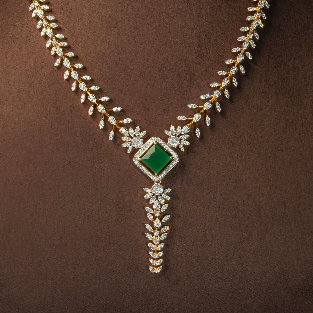 Luxury diamond-look silver cz emerald necklace with premium cz stones and semi-precious emerald stone in 92.5 silver, bridal wedding jewellery with gold finish by Sri Fine Jewellery Punjagutta Hyderabad.