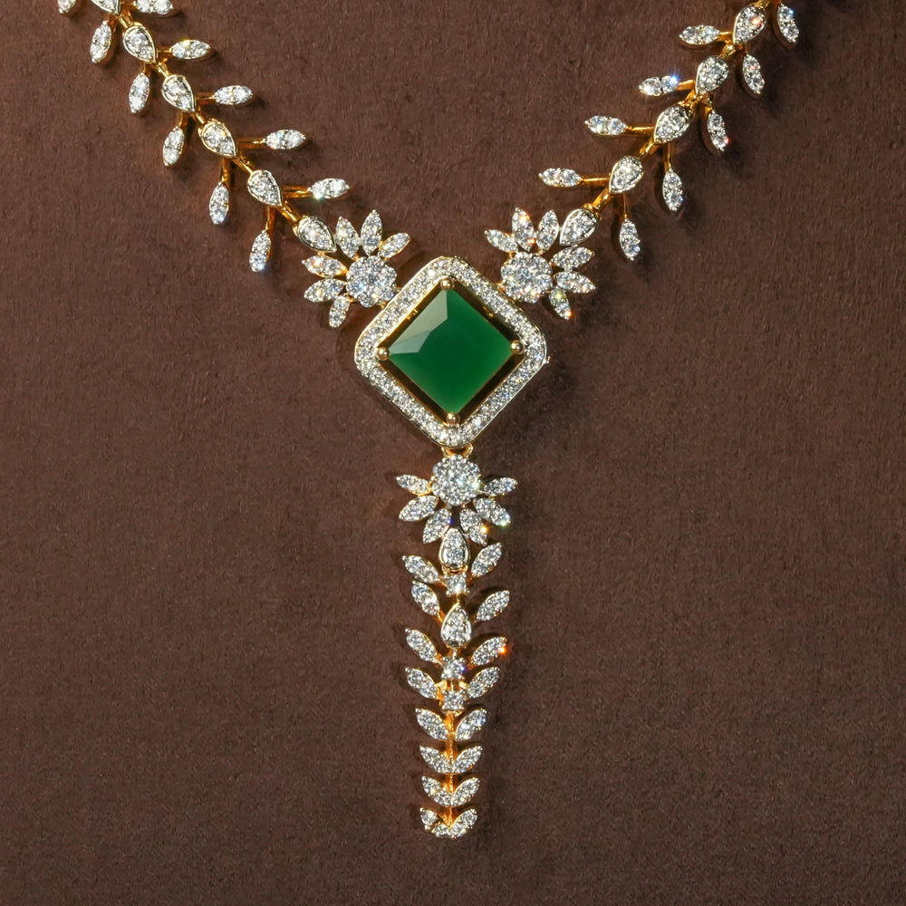 Close-up view of uxury diamond-look silver cz emerald necklace with premium cz stones and semi-precious emerald stone in 92.5 silver, bridal wedding jewellery with gold finish by Sri Fine Jewellery Punjagutta Hyderabad.