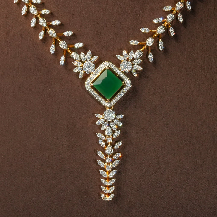 Close-up view of uxury diamond-look silver cz emerald necklace with premium cz stones and semi-precious emerald stone in 92.5 silver, bridal wedding jewellery with gold finish by Sri Fine Jewellery Punjagutta Hyderabad.