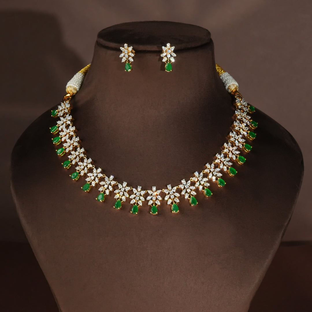 Luxury diamond-look silver necklace set with premium cz stones and semi-precious emerald stones in 92.5 silver, bridal wedding jewellery with gold finish by Sri Fine Jewellery Punjagutta Hyderabad.