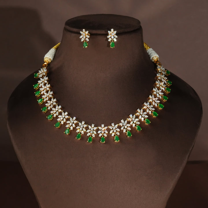 Luxury diamond-look silver necklace set with premium cz stones and semi-precious emerald stones in 92.5 silver, bridal wedding jewellery with gold finish by Sri Fine Jewellery Punjagutta Hyderabad.