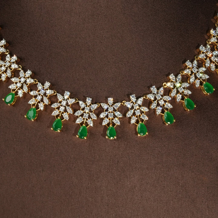 Close-up view of luxury diamond-look silver necklace set with premium cz stones and semi-precious emerald stones in 92.5 silver, bridal wedding jewellery with gold finish by Sri Fine Jewellery Punjagutta Hyderabad.