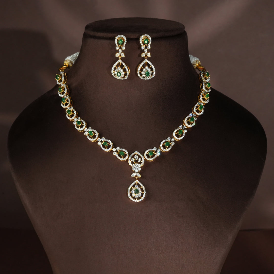 Luxury diamond-look silver necklace set with premium cz stones and semi-precious emerald stones in 92.5 silver, bridal wedding jewellery with gold finish by Sri Fine Jewellery Punjagutta Hyderabad.