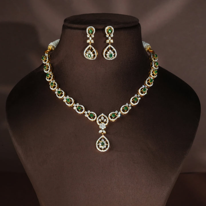 Luxury diamond-look silver necklace set with premium cz stones and semi-precious emerald stones in 92.5 silver, bridal wedding jewellery with gold finish by Sri Fine Jewellery Punjagutta Hyderabad.