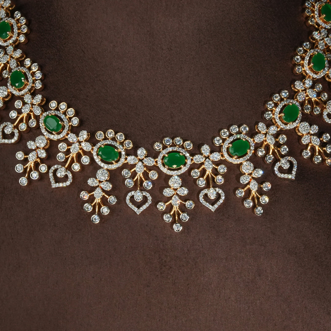 Luxury diamond-look silver necklace with premium cz stones and semi-precious emerald stones in 92.5 silver, bridal wedding jewellery with gold finish by Sri Fine Jewellery Punjagutta Hyderabad.