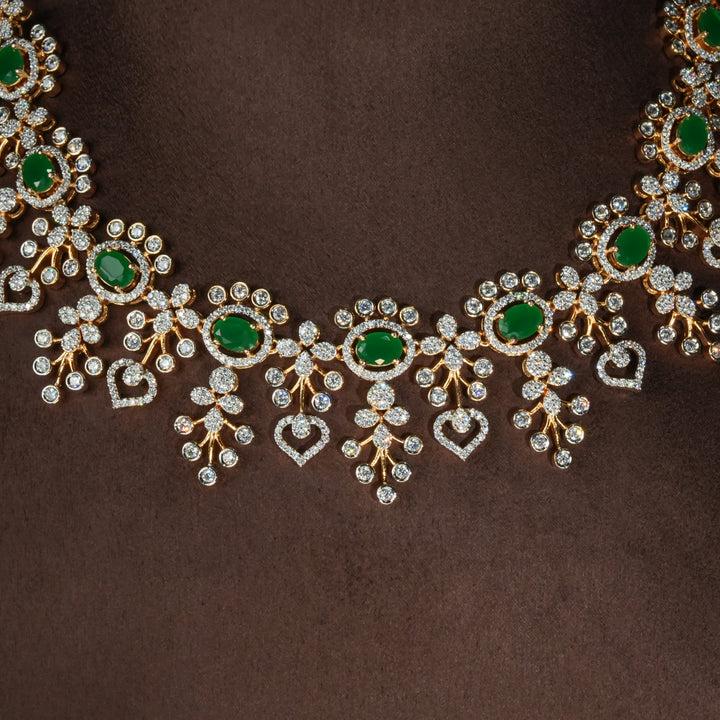 Luxury diamond-look silver necklace with premium cz stones and semi-precious emerald stones in 92.5 silver, bridal wedding jewellery with gold finish by Sri Fine Jewellery Punjagutta Hyderabad.
