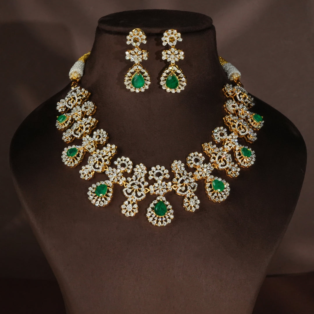 Luxury diamond-look silver necklace set with premium cz stones and semi-precious emerald stones in 92.5 silver, bridal wedding jewellery with gold finish by Sri Fine Jewellery Punjagutta Hyderabad.