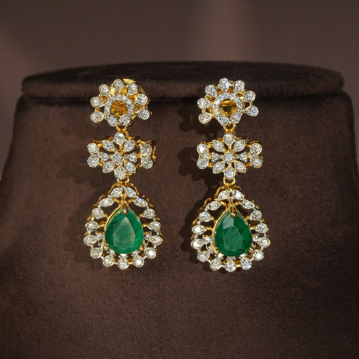 Luxury diamond-look silver earrings with premium cz stones and semi-precious emerald stones in 92.5 silver, bridal wedding jewellery with gold finish by Sri Fine Jewellery Punjagutta Hyderabad.