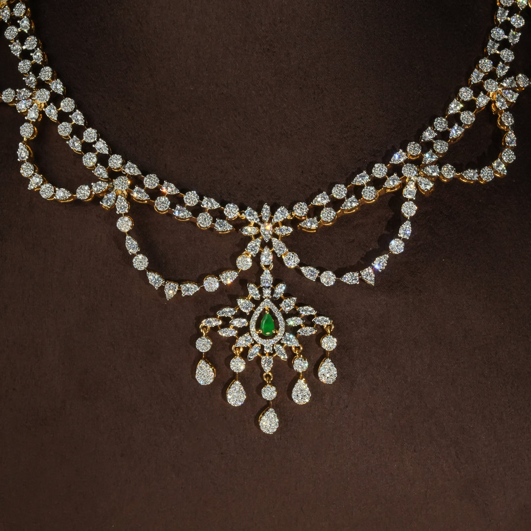 Close-up view of luxury diamond-look silver necklace with premium cz stones and semi-precious emerald stones in 92.5 silver, bridal wedding jewellery with gold finish by Sri Fine Jewellery Punjagutta Hyderabad.