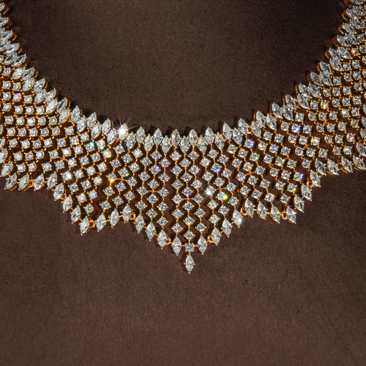 Close-up view of luxury diamond-look silver necklace with premium cz stones and matching earrings in 92.5 silver, bridal wedding jewellery with gold finish by Sri Fine Jewellery Punjagutta Hyderabad.