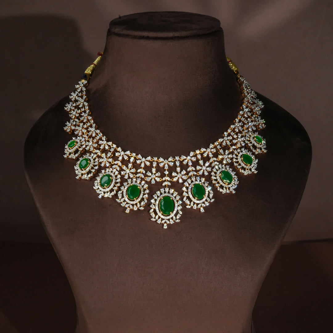 Luxury diamond-look silver necklace set with premium cz stones and semi-precious emerald accents in 92.5 silver, bridal wedding jewellery with gold finish by Sri Fine Jewellery Punjagutta Hyderabad.