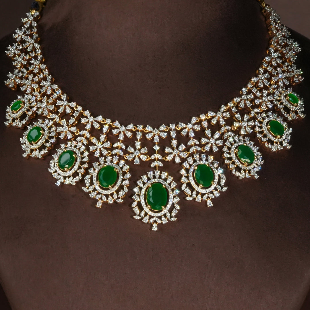 Luxury diamond-look silver necklace set with premium cz stones and semi-precious emerald accents in 92.5 silver, bridal wedding jewellery with gold finish by Sri Fine Jewellery Punjagutta Hyderabad.