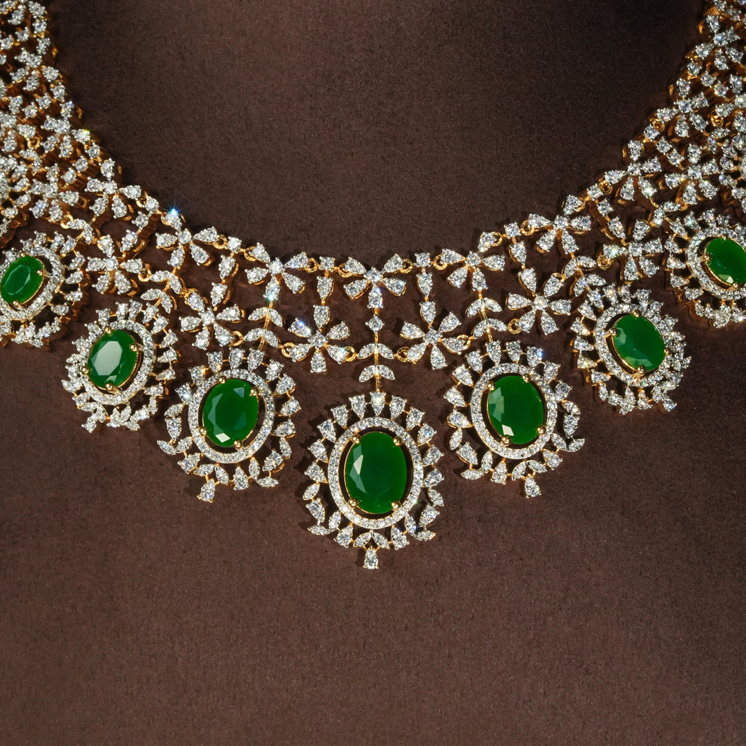 Luxury diamond-look silver necklace set with premium cz stones and semi-precious emerald accents in 92.5 silver, bridal wedding jewellery with gold finish by Sri Fine Jewellery Punjagutta Hyderabad.