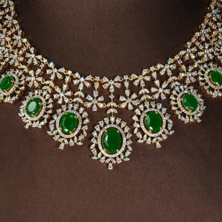 Luxury diamond-look silver necklace set with premium cz stones and semi-precious emerald accents in 92.5 silver, bridal wedding jewellery with gold finish by Sri Fine Jewellery Punjagutta Hyderabad.