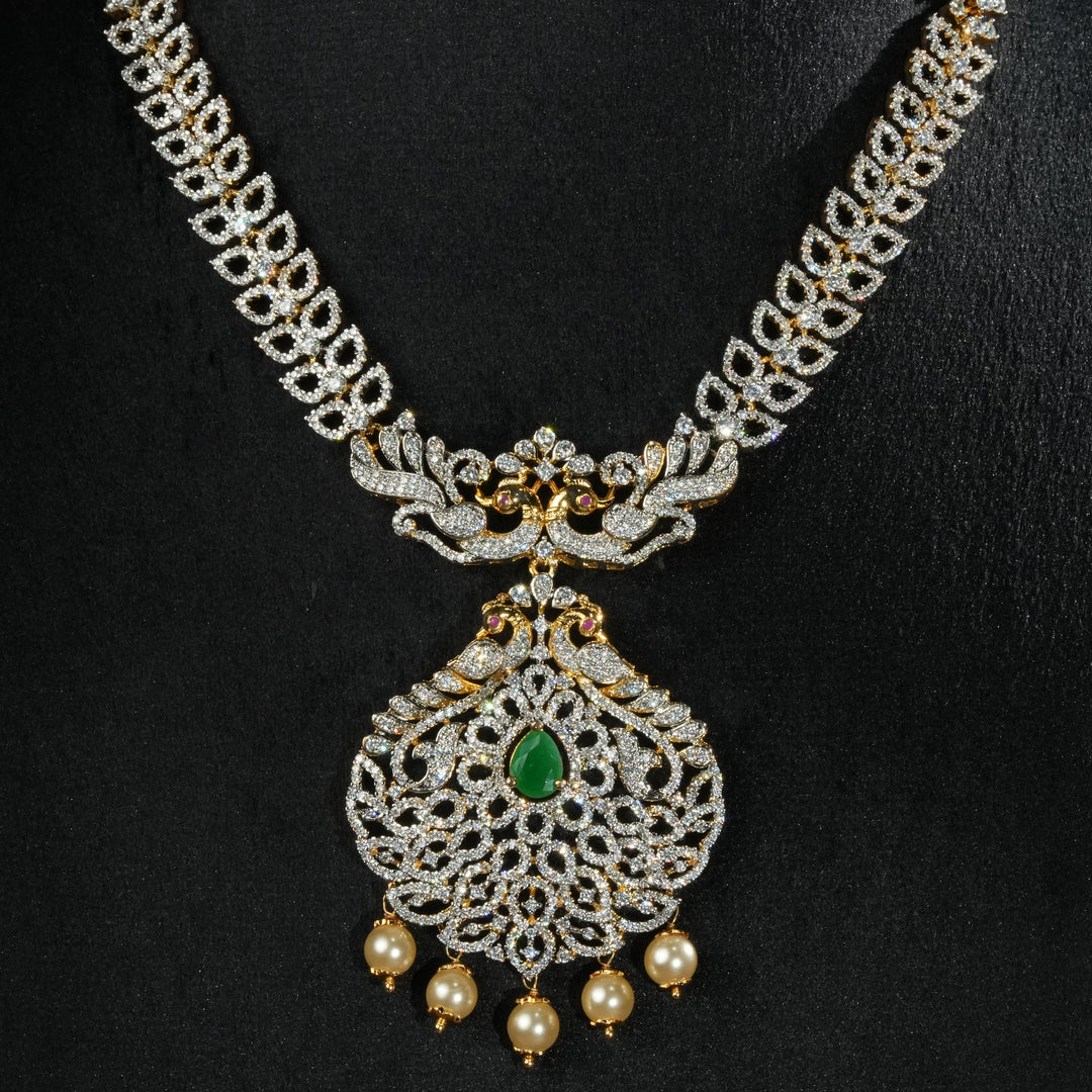 Luxury diamond-look silver necklace with premium cz stones and semi-precious emerald accents in 92.5 silver, bridal wedding jewellery with gold finish by Sri Fine Jewellery Punjagutta Hyderabad.