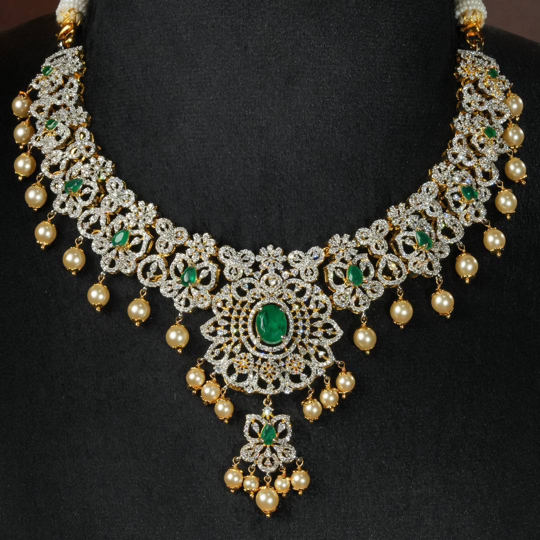 Luxury diamond-look silver necklace with premium cz stones and semi-precious emerald stones in 92.5 silver, bridal wedding jewellery with gold finish by Sri Fine Jewellery Punjagutta Hyderabad.