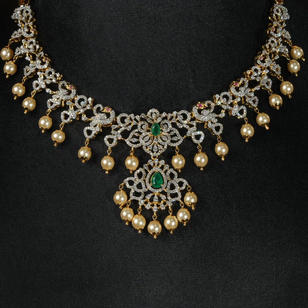 Luxury diamond-look silver necklace with premium cz stones and semi-precious emerald stones in 92.5 silver, bridal wedding jewellery with gold finish by Sri Fine Jewellery Punjagutta Hyderabad.