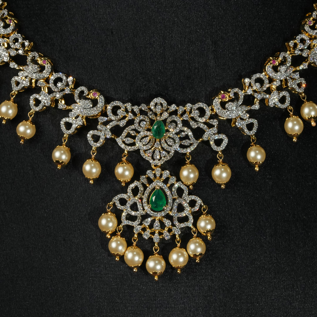 Luxury diamond-look silver necklace with premium cz stones and semi-precious emerald stones in 92.5 silver, bridal wedding jewellery with gold finish by Sri Fine Jewellery Punjagutta Hyderabad.