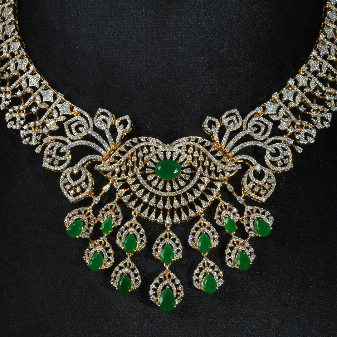 Luxury diamond-look silver necklace with premium cz stones and semi-precious emerald stones in 92.5 silver, bridal wedding jewellery with gold finish by Sri Fine Jewellery Punjagutta Hyderabad.