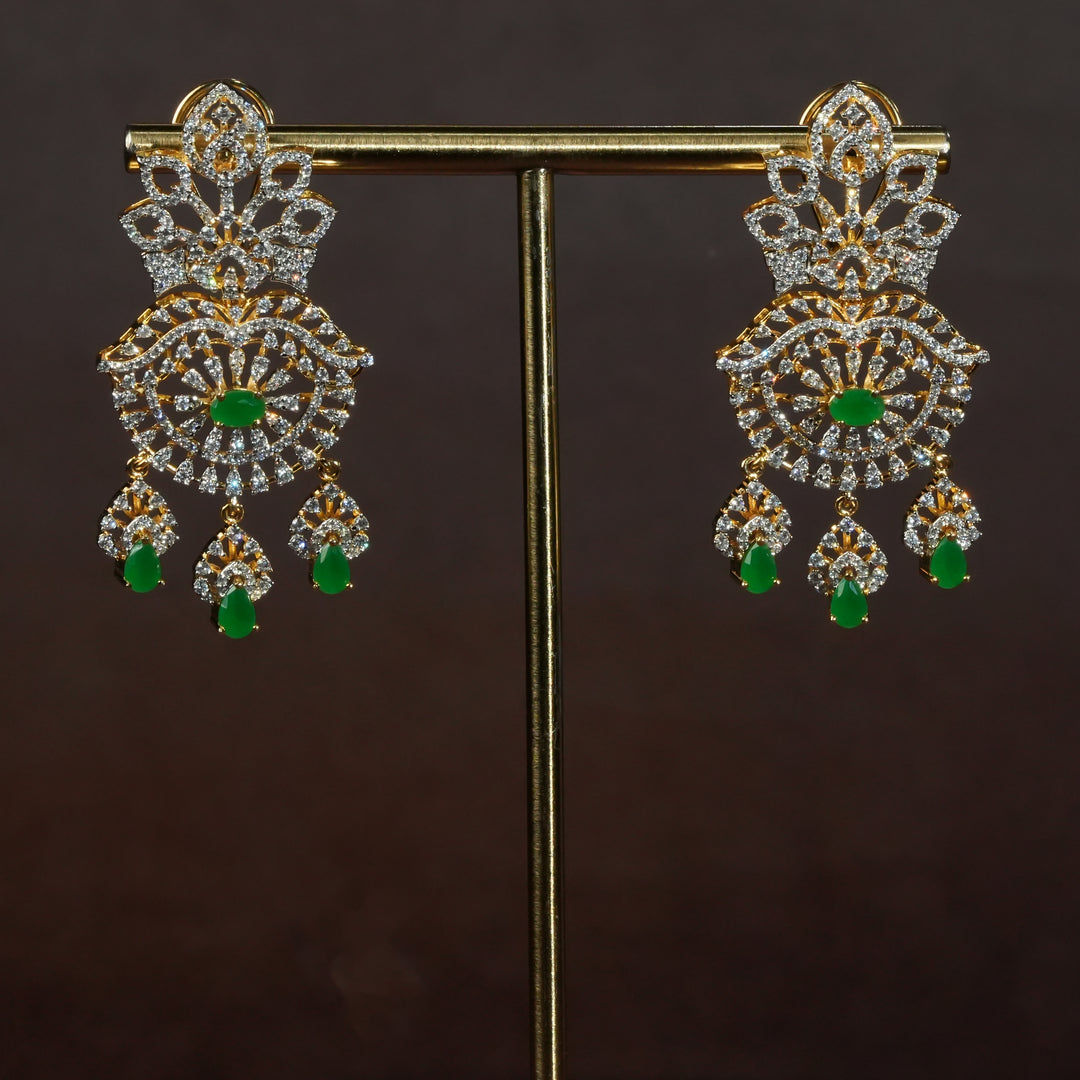 Luxury diamond-look silver earrings with premium cz stones and semi-precious emerald stones in 92.5 silver, bridal wedding jewellery with gold finish by Sri Fine Jewellery Punjagutta Hyderabad.