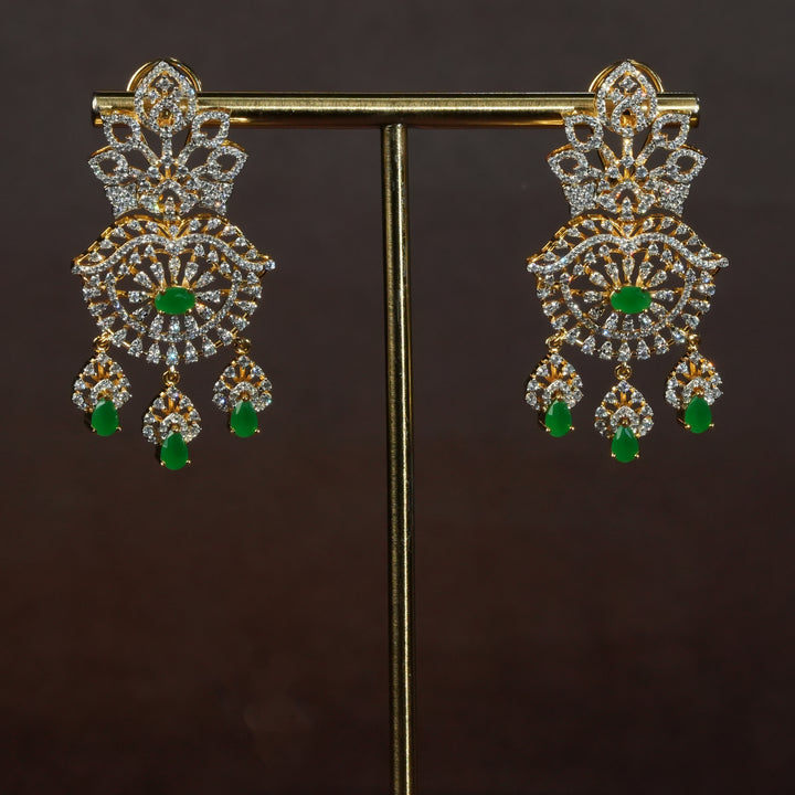 Luxury diamond-look silver earrings with premium cz stones and semi-precious emerald stones in 92.5 silver, bridal wedding jewellery with gold finish by Sri Fine Jewellery Punjagutta Hyderabad.