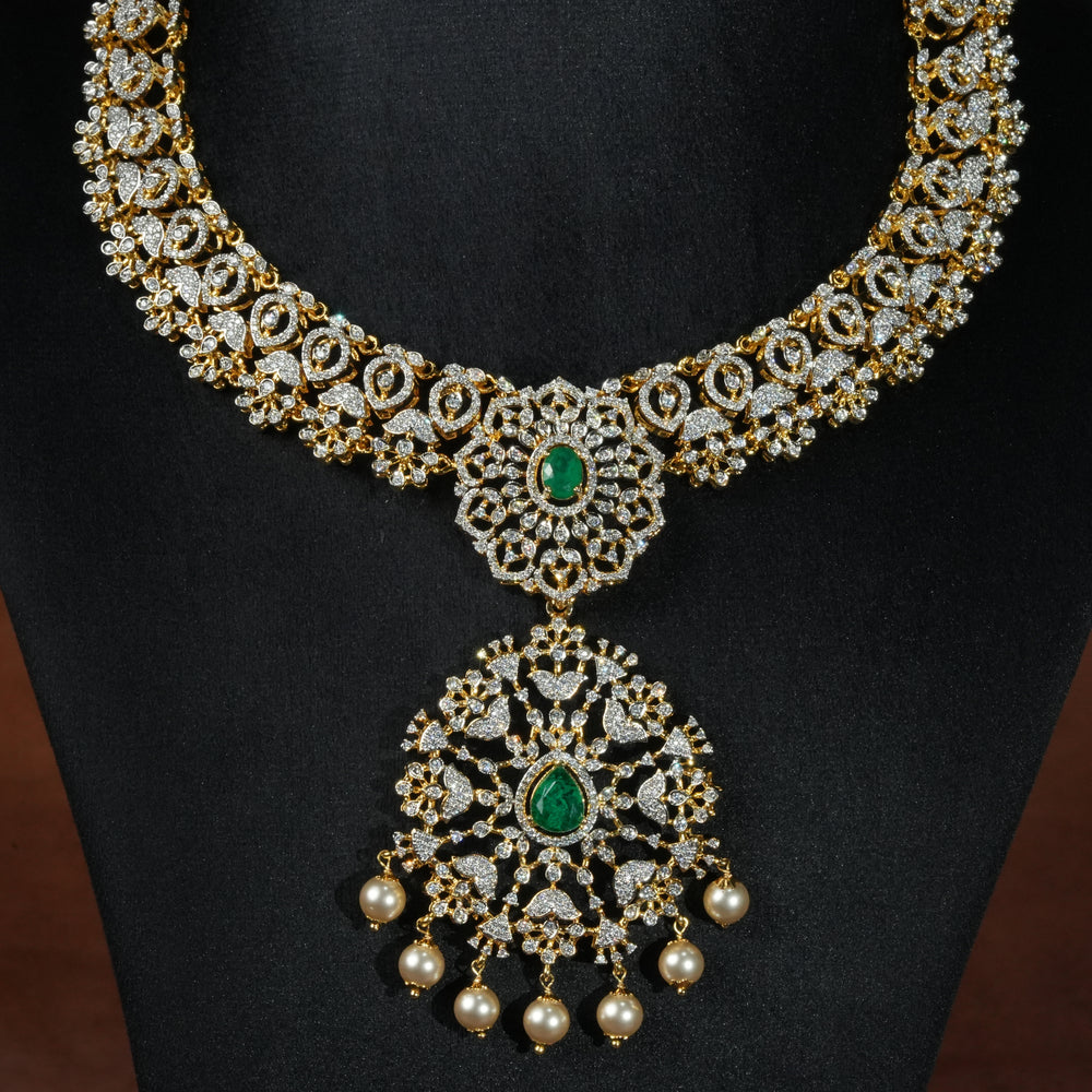 Luxury diamond-look silver necklace with premium cz stones and semi-precious emerald stones in 92.5 silver, bridal wedding jewellery with gold finish by Sri Fine Jewellery Punjagutta Hyderabad.