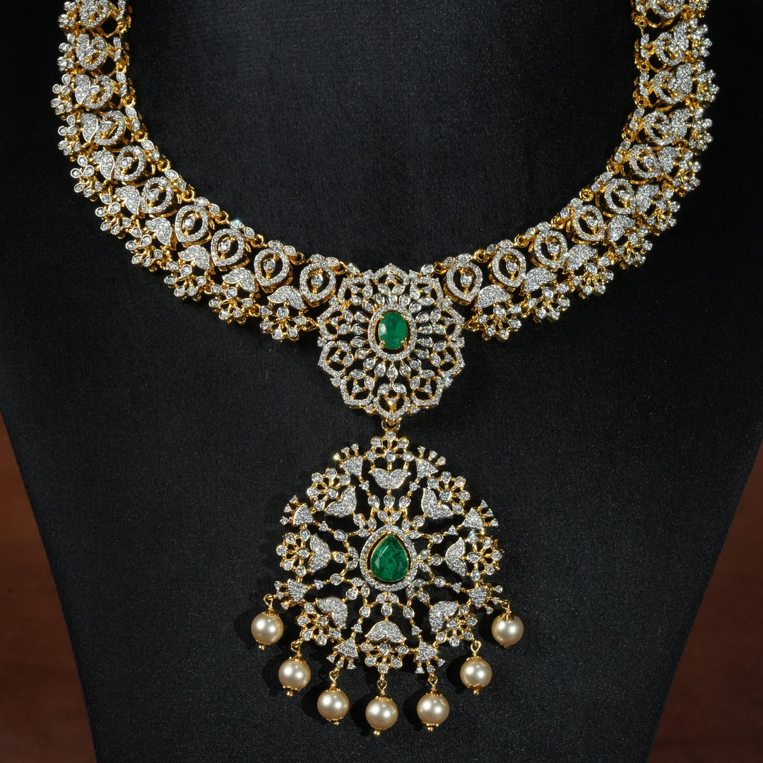 Luxury diamond-look silver necklace with premium cz stones and semi-precious emerald stones in 92.5 silver, bridal wedding jewellery with gold finish by Sri Fine Jewellery Punjagutta Hyderabad.