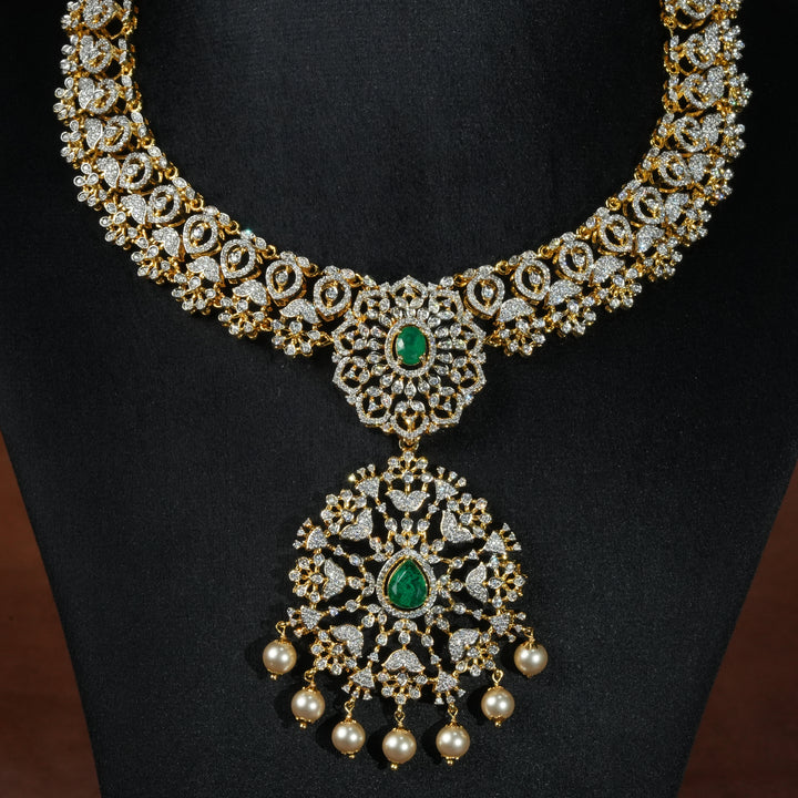 Luxury diamond-look silver necklace with premium cz stones and semi-precious emerald stones in 92.5 silver, bridal wedding jewellery with gold finish by Sri Fine Jewellery Punjagutta Hyderabad.
