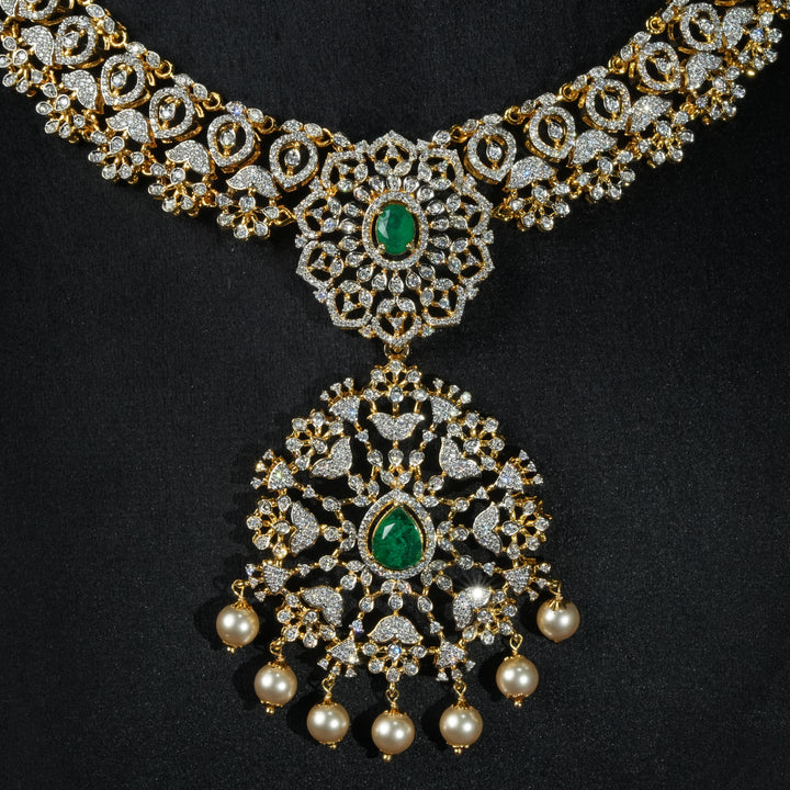 Luxury diamond-look silver necklace with premium cz stones and semi-precious emerald stones in 92.5 silver, bridal wedding jewellery with gold finish by Sri Fine Jewellery Punjagutta Hyderabad.