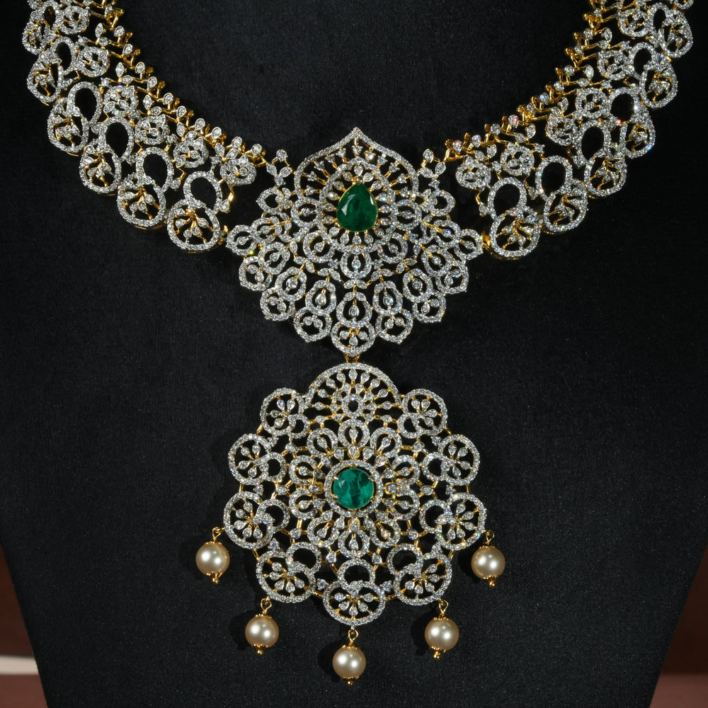 Luxury diamond-look silver necklace with premium cz stones and semi-precious emerald stones in 92.5 silver, bridal wedding jewellery with gold finish by Sri Fine Jewellery Punjagutta Hyderabad.