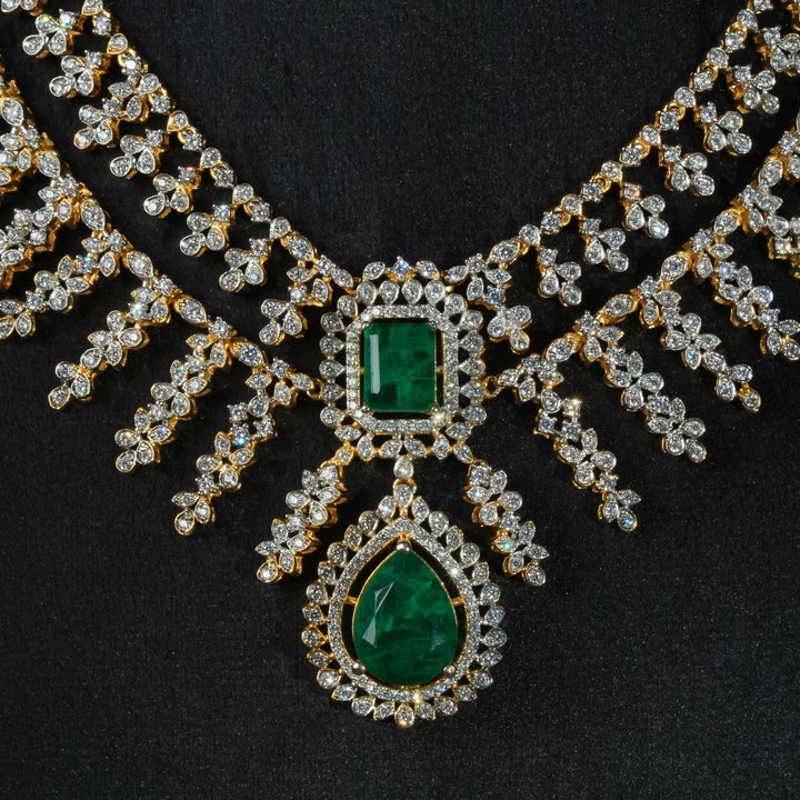 Luxury diamond-look silver necklace with premium cz stones and semi-precious emerald stones in 92.5 silver, bridal wedding jewellery with gold finish by Sri Fine Jewellery Punjagutta Hyderabad.