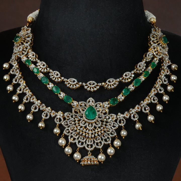 Luxury diamond-look silver necklace with premium cz stones and semi-precious emerald stones in 92.5 silver, bridal wedding jewellery with gold finish by Sri Fine Jewellery Punjagutta Hyderabad.
