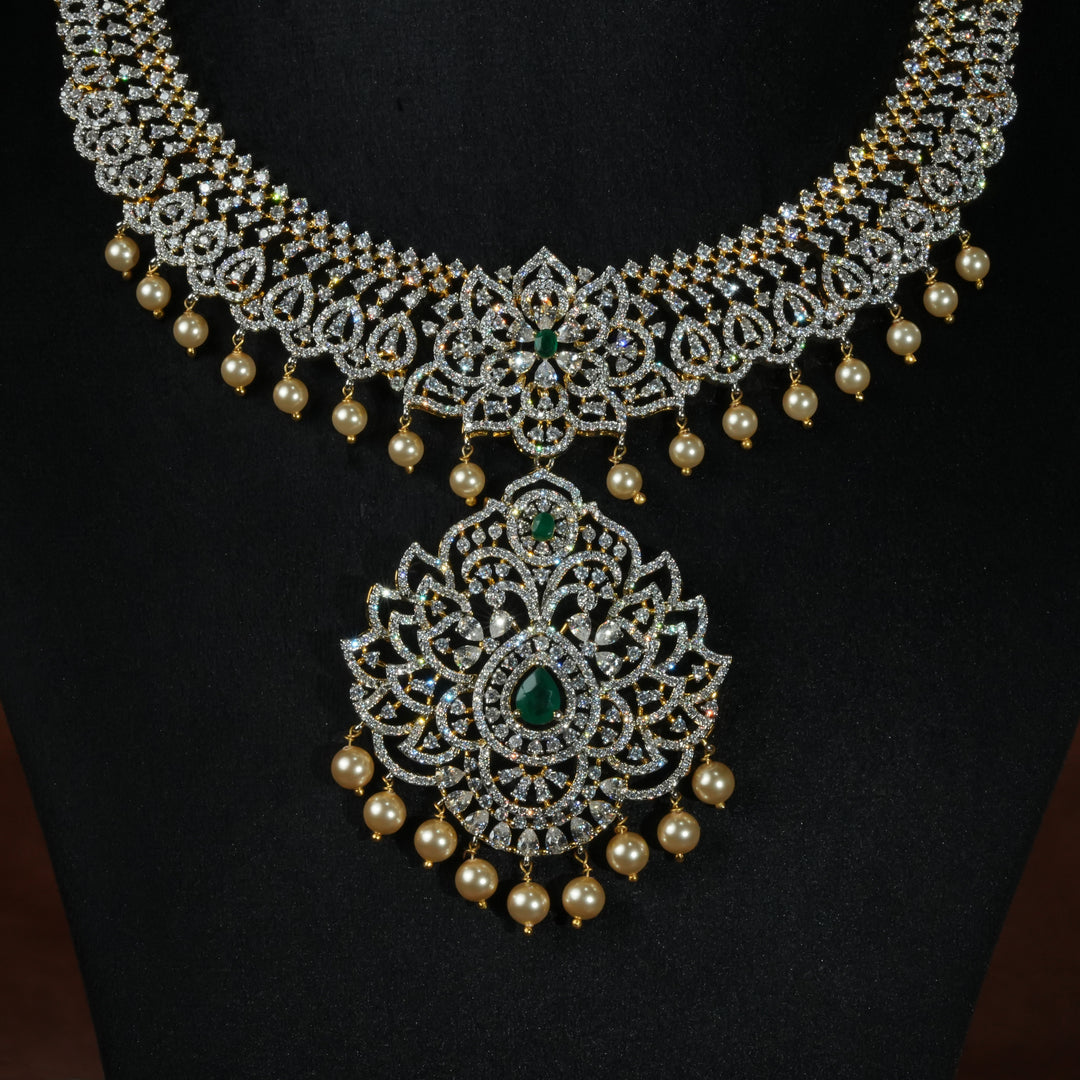 Luxury diamond-look silver necklace with premium cz stones and semi-precious emerald stones in 92.5 silver, bridal wedding jewellery with gold finish by Sri Fine Jewellery Punjagutta Hyderabad.