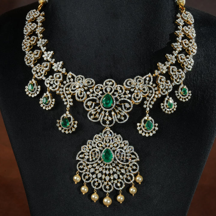 Luxury diamond-look silver necklace with premium cz stones and semi-precious emerald stones in 92.5 silver, bridal wedding jewellery with gold finish by Sri Fine Jewellery Punjagutta Hyderabad.