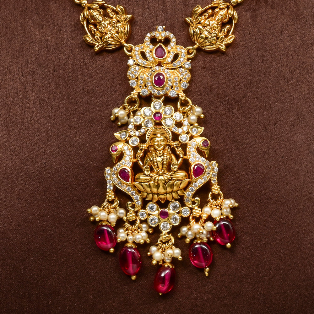 Close-up view of elegant 92.5 silver temple necklace featuring intricate Lakshmi motif craftsmanship with ruby-toned stones, pearl detailing, and traditional antique gold finish. 
Sri Fine Jewellery, Hyderabad