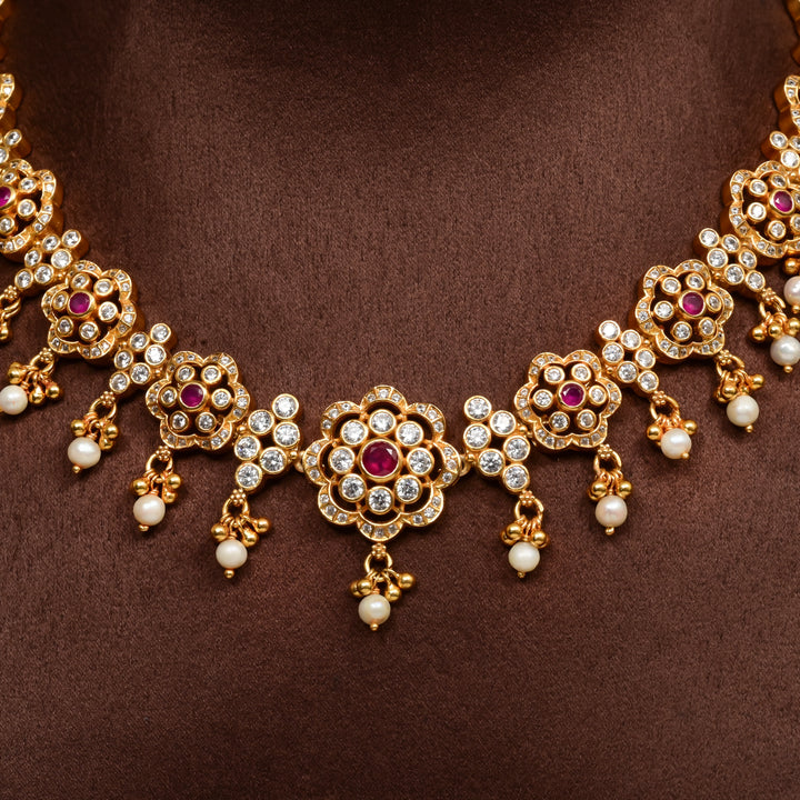 Close-up of 92.5 silver floral necklace with cz stones, ruby accents, pearl drops, and gold finish design by Sri Fine Jewellery Hyderabad.
